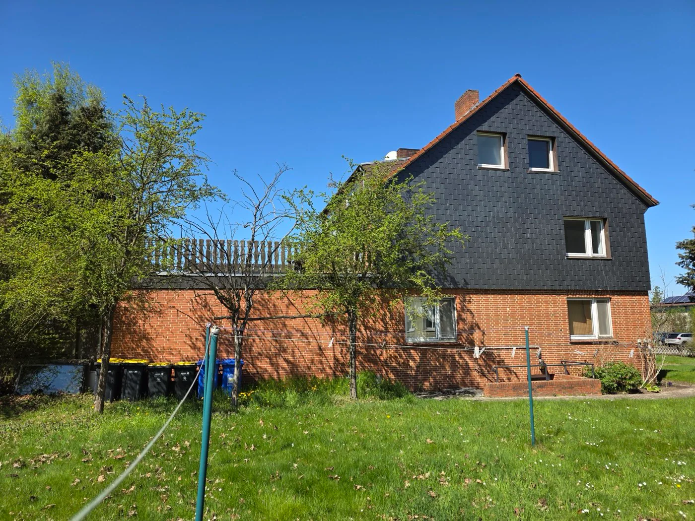 Seitenansicht des Hauses mit Anbau im Erdgeschoss und Terrasse im 1. Obergeschoss